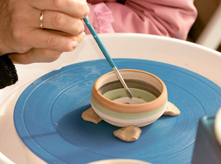  teacher helps the pupil in the ceramics painting at the festival in Ukraine