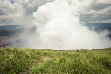Obraz na płótnie Canvas Very active heavily fuming crater of the Masaya Nindiri volcanic duo in Nicaragua. Dramatic sky. Central America
