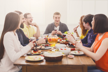Group of happy people drink wine at festive table dinner party