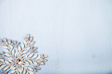 Silvery snowflake on a  wooden background.