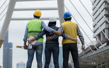 Asian teamwork engineer and architect standing and hand up together ready to work to success