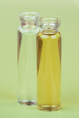 Homeopathic Extract - Closeup image of bottles containing a liquid homeopathic extract/liquid on a green background.