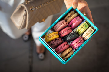 Woman holding box with colourful macaroons