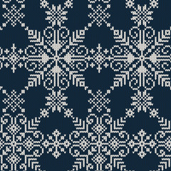 Seamless knitted pattern of white snowflakes on a blue background