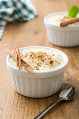 Arroz con leche. Rice pudding with cinnamon on wooden background