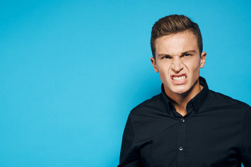 a man in a black shirt on a blue background is angry