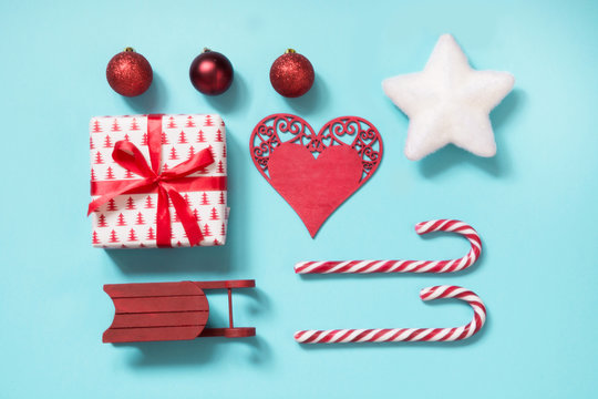 Christmas collection with candy canes, heart, balls, red sleid for mock up template design on blue. Flat lay. Top view.