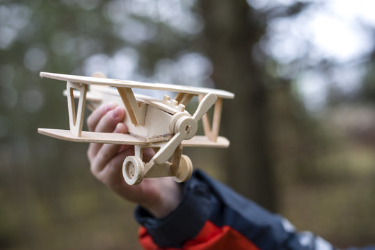 a wooden plane in the hands of a child