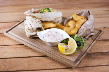 Burrito with grilled chicken and vegetables. Shawarma from juicy beef, lettuce, tomatoes, cucumbers, paprika and onion in pita bread.