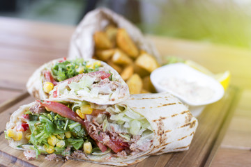 Burrito with grilled chicken and vegetables. Shawarma from juicy beef, lettuce, tomatoes, cucumbers, paprika and onion in pita bread.