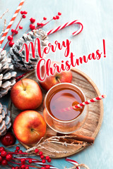 Seasonal and holidays concept. Winter hot tea in a glass with apples and spices on a wooden background. Selective focus, top view