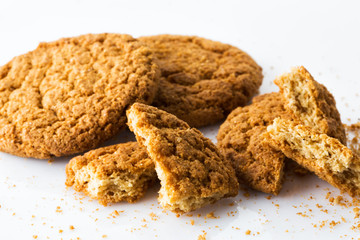cracked oatmeal cookies with crumbs isolated on white background