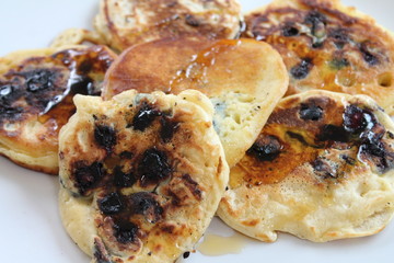 Homemade blueberry pancakes drizzled with maple syrup