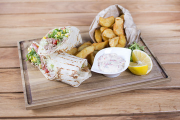 Burrito with grilled chicken and vegetables. Shawarma from juicy beef, lettuce, tomatoes, cucumbers, paprika and onion in pita bread.