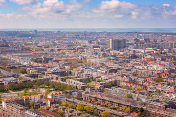 Fototapeta premium Aerial wide-angle cityscape of The Hague (Den Haag) with the North Sea and cloudy blue sky, Netherlands
