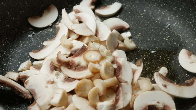 putting Mushrooms on a pan with oil, Close-up