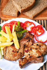 Grilled juicy steak on the bone with vegetables on a dark wooden background.