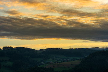 Naklejka na ściany i meble Romantic colorful sunset over black forest near Freiburg with orange sky and misty atmosphere