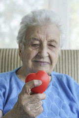 senior woman holding a red heart