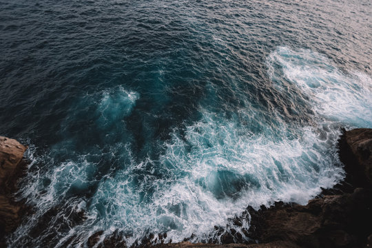 Fototapeta Aerial view to ocean waves and rock coast