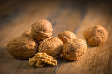 Walnut kernels and whole walnuts on rustic old oak table