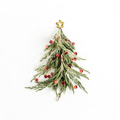 Christmas tree made of baubles and branch on white background. Flat lay, top view holiday concept.
