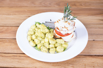 Nice stuffed meat with tomatoes with gnocchi. White cream topping with the touch of green seasoning. Beautifully served plate at the restaurant.