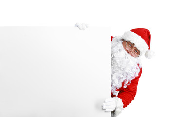 Happy Santa Claus looking out from behind the blank sign isolated on white background