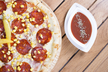 Hot pizza with melting cheese on a rustic wooden table. Delicious meal in the restaurant.