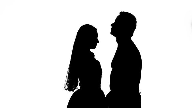 Guy with the girl hugs and looks at the sky. Silhouette. White background