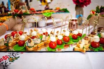 Fresh fruits and berries of different bright colors cut in small pieces are served on a table in restourant