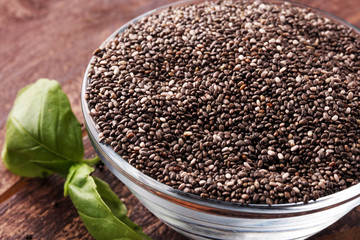 Healthy Chia seeds in a glass bowl wooden background.