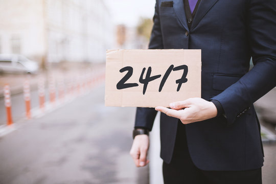 Street city, a man holding a sign in his hands with the inscription "24/7"