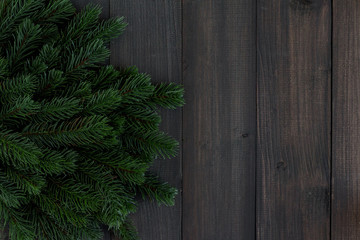 Christmas fir tree branches and pine on dark rustic wooden background with copy space for text