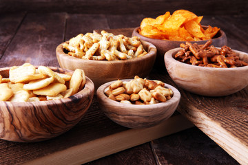 Salty snacks. Pretzels, chips, crackers in wooden bowls.