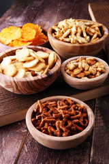 Salty snacks. Pretzels, chips, crackers in wooden bowls.