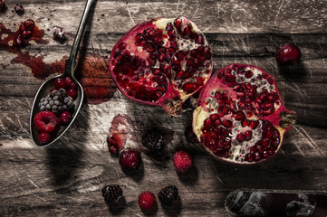 Sliced pomegranate on rustic wooden background. Health care concept. 