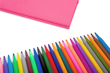 Notebook and multicolored markers on a white background