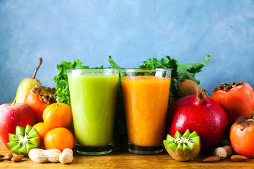 Freshly blended fruit smoothies of various colors and tastes in glass  in wooden tray. Yellow, green. on wooden table and blue background