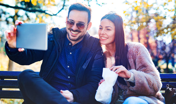 Couple making a selfie with tablet in the autumn park. Love and tenderness. Relationships, friendship, lifestyle concept