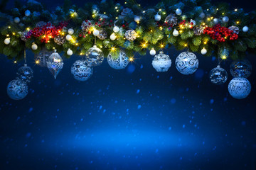 Art Christmas holiday decoration; Fir tree Branches and holiday light on blue snowy background