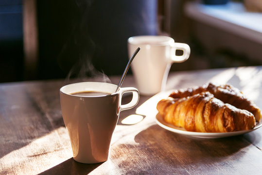 breakfast for two person with cup of hot coffee and fresh croiss