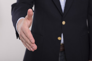 Businessman giving his hand for handshake to partner