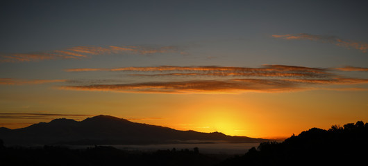 Mount Diablo sunrise panorama over Contra Costa County California showing high clouds and orange sky