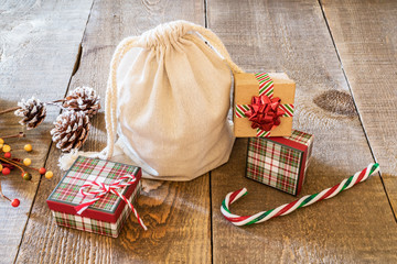 Rustic gift sack with candy canes and pine cones on wooden surface - Powered by Adobe