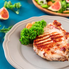 Grilled steaks on a gray plate blue background