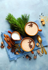 Fototapeta na wymiar Masala tea chai latte traditional hot Indian teatime ceremony sweet milk with spices, herbs organic infusion healthy beverage in porcelain cup on blue table background