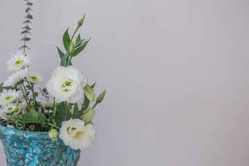 Whilte lisianthus in turquoise vase with copy space