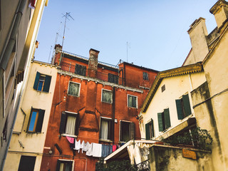 little girl one year with blue eyes blonde in a lush white dress is pleased and plays in a bright room on background of an Indian tent