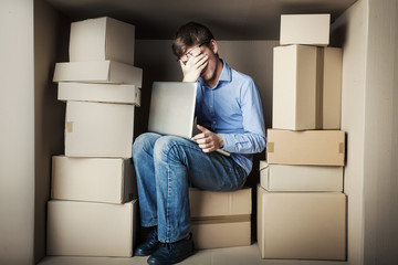 teenager student in small office working on laptop, tired